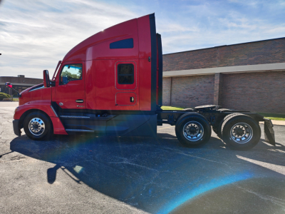 Kenworth T680 semi truck in red with sleeper cab, side view showing drivetrain and rear axles; stock number 0635674 and VIN 1XKYD49X0RJ344731 not visible in image.