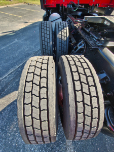 Kenworth truck rear dual rear axles with tires and wheel hubs visible; no legible labels or stickers in view.