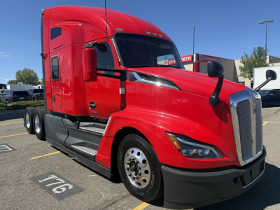 Kenworth T680 conventional sleeper truck in red, front-side view showing two-axle tractor with chrome grille, large fuel tanks, and black bumper.