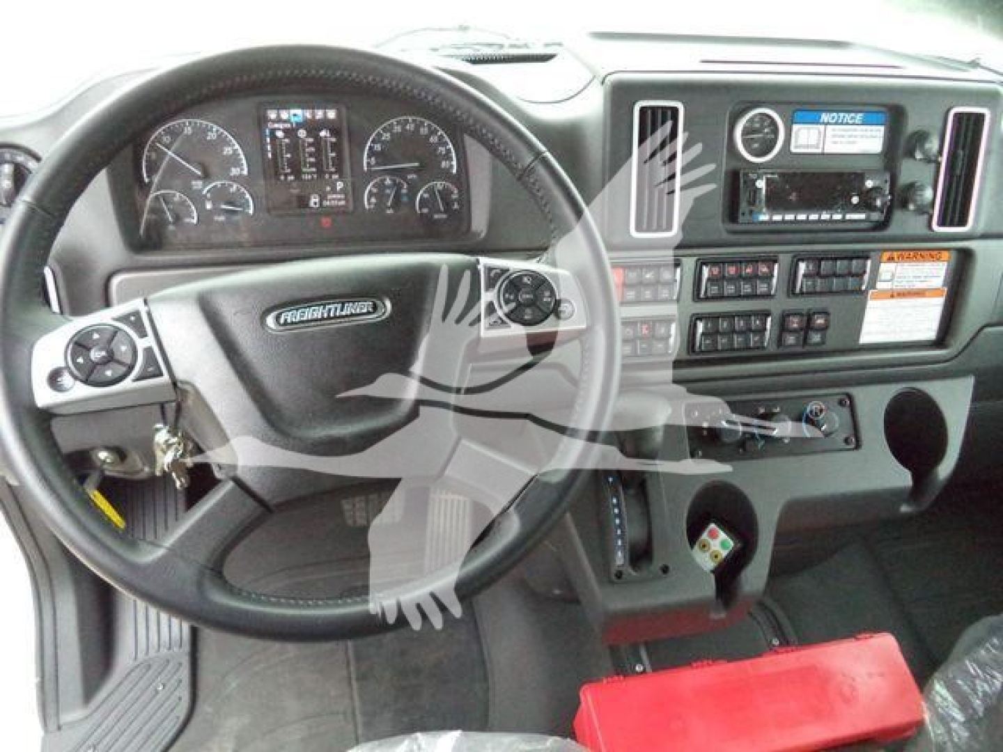 Freightliner M2 106 cockpit showing steering wheel and dashboard controls with Dodge-like center console and instrument cluster.