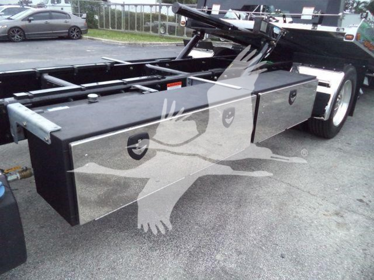 Freightliner M2 106 rollback truck chassis with long black toolbox and flatbed area visible, side storage box and wheel on right.