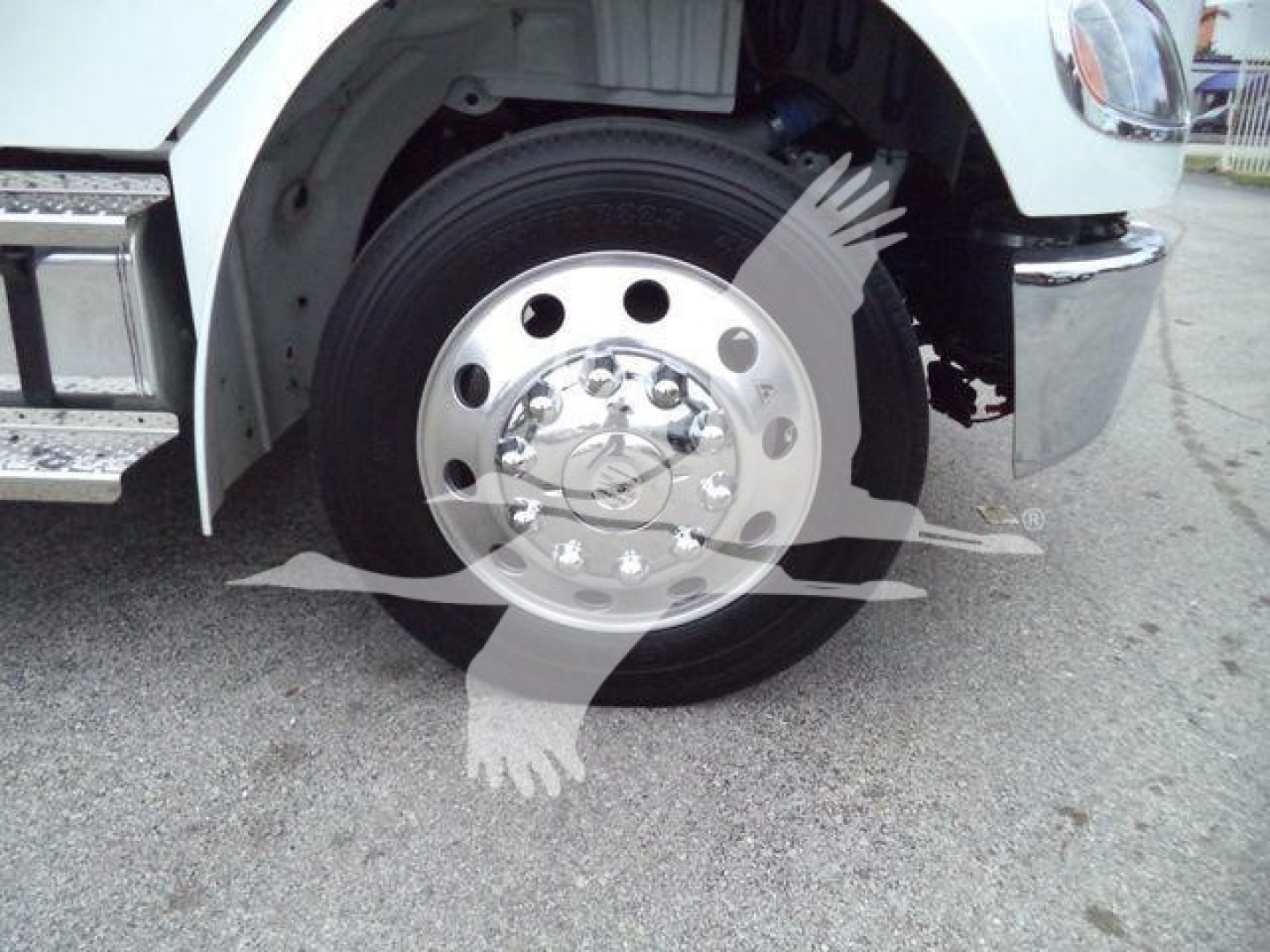 Wheel area of a Freightliner M2 106 class truck showing front wheel, hub and fender; no legible sticker or model text visible.