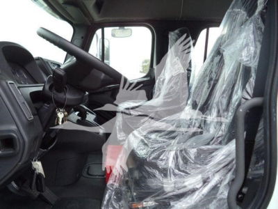 Truck cab interior of a 2027 Freightliner M2 106 with plastic-covered seats, steering wheel, dashboard, and keys in ignition.
