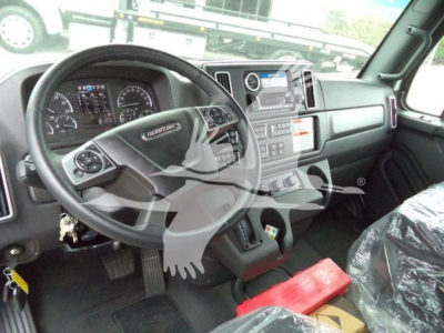 Freightliner M2 106 cab interior showing steering wheel dashboard and center console without visible text