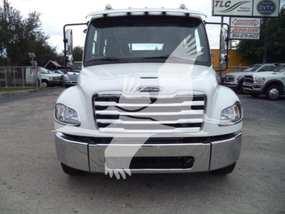 Front view of a white 2027 Freightliner M2 106 roll back truck showing grille, bumper, headlights and windshield; dealership lot in background.
