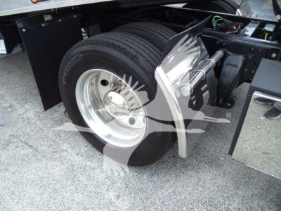 Freightliner M2 106 rollback truck wheel and fender area with dual rear tires and chrome hub showing front wheel well.