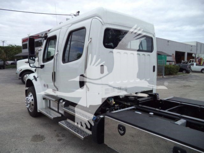 Truck cab side view showing Freightliner M2 106 rollback chassis with steps, side rail, and dual rear wheels, stock JU6165.