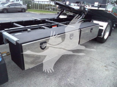 Freightliner M2 106 rollback truck chassis with long black toolbox and flatbed area visible, side storage box and wheel on right.