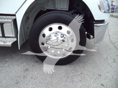 Wheel area of a Freightliner M2 106 class truck showing front wheel, hub and fender; no legible sticker or model text visible.