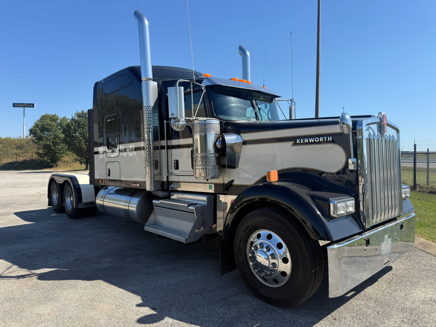 Kenworth W900L conventional sleeper truck showing chrome exhaust stacks, front grille, and dual rear axles.