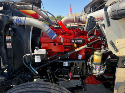 Kenworth W900L engine bay showing CX15 badge and red engine with various hoses and components