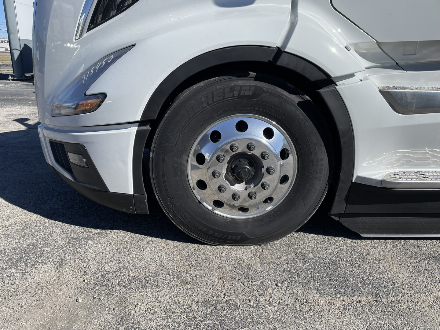 Volvo VNL64T860 front wheel area showing chrome steel wheel and tire labeled with Volvo hub and black rubber surface