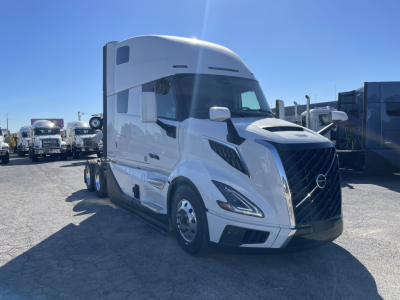 Volvo VNL64T860 tractor-trailer in white, front-left view with aerodynamic headlights and grille, VIN tag not visible, new conventional sleeper truck.