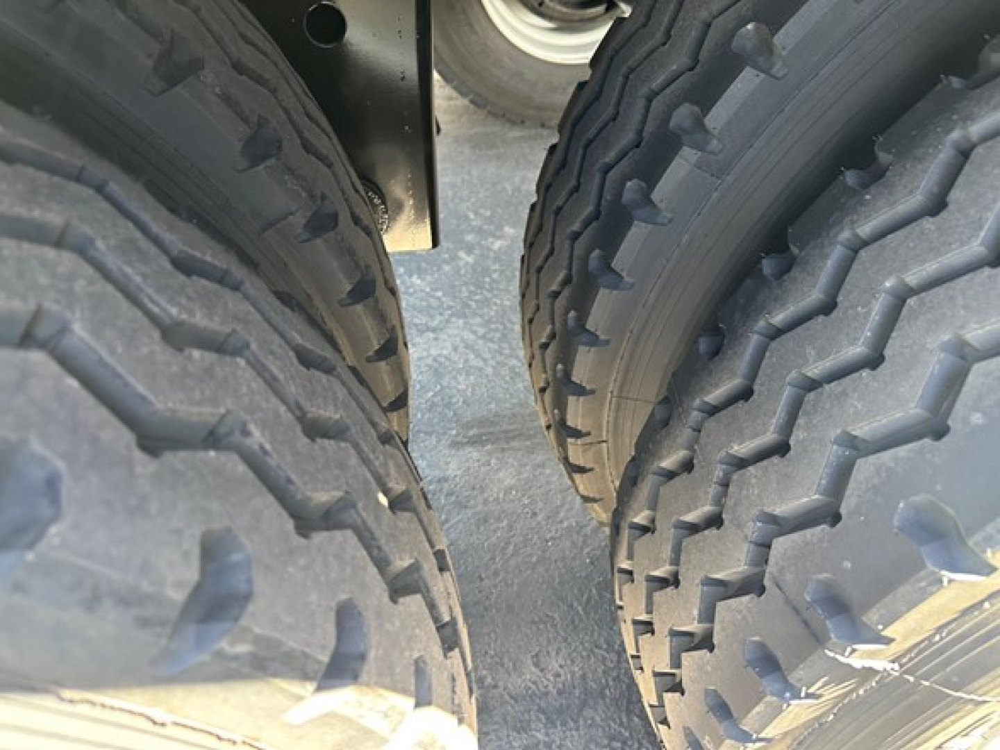 Smithco air ride side dump trailer wheel area showing dual near-tires with deep tread patterns and suspension components.