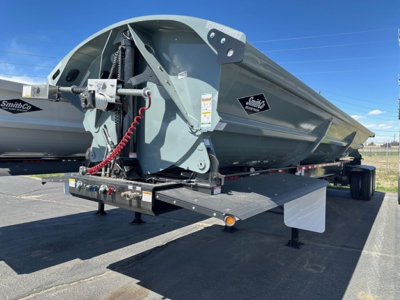 Trailer side dump bed showing hydraulic lift and undercarriage components with SmithCo branding.