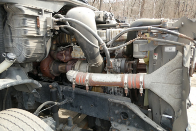 Freightliner Cascadia 125 engine bay view showing turbocharger, intercooler piping, coolant lines, and engine components.