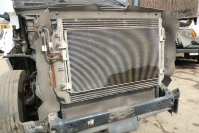 Truck radiator and front grille area of a Freightliner Cascadia 125 truck showing the cooling radiator and surrounding metal frame.
