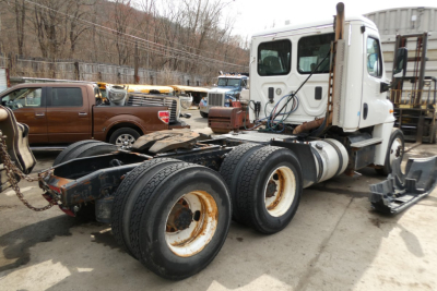 Truck chassis and cab of a Freightliner Cascadia 125, rear view showing dual rear axles and exposed frame.