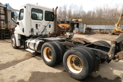 Truck chassis and cab of a Freightliner Cascadia 125 with exposed rear axles and fuel tanks