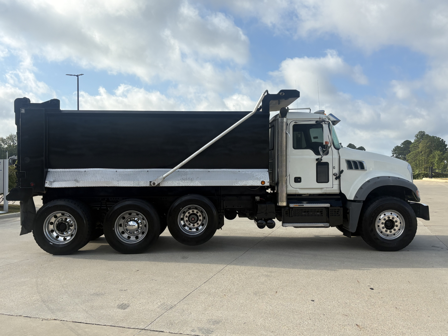 2022 Mack GR64F dump truck side view showing dump bed, wheels, and cab with VIN and stock details on listing.