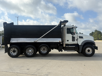 2022 Mack GR64F dump truck side view showing dump bed, wheels, and cab with VIN and stock details on listing.