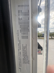 Mack GR64F truck door jamb label with VIN 1M2GR2GC7NM026834 and weight/GAWR details visible in close-up.