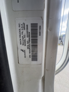 Mack Trucks label on side of cab showing VIN 1M2GR2GC7NM026834 and stock number B3736P; barcodes and text including model and serial details.