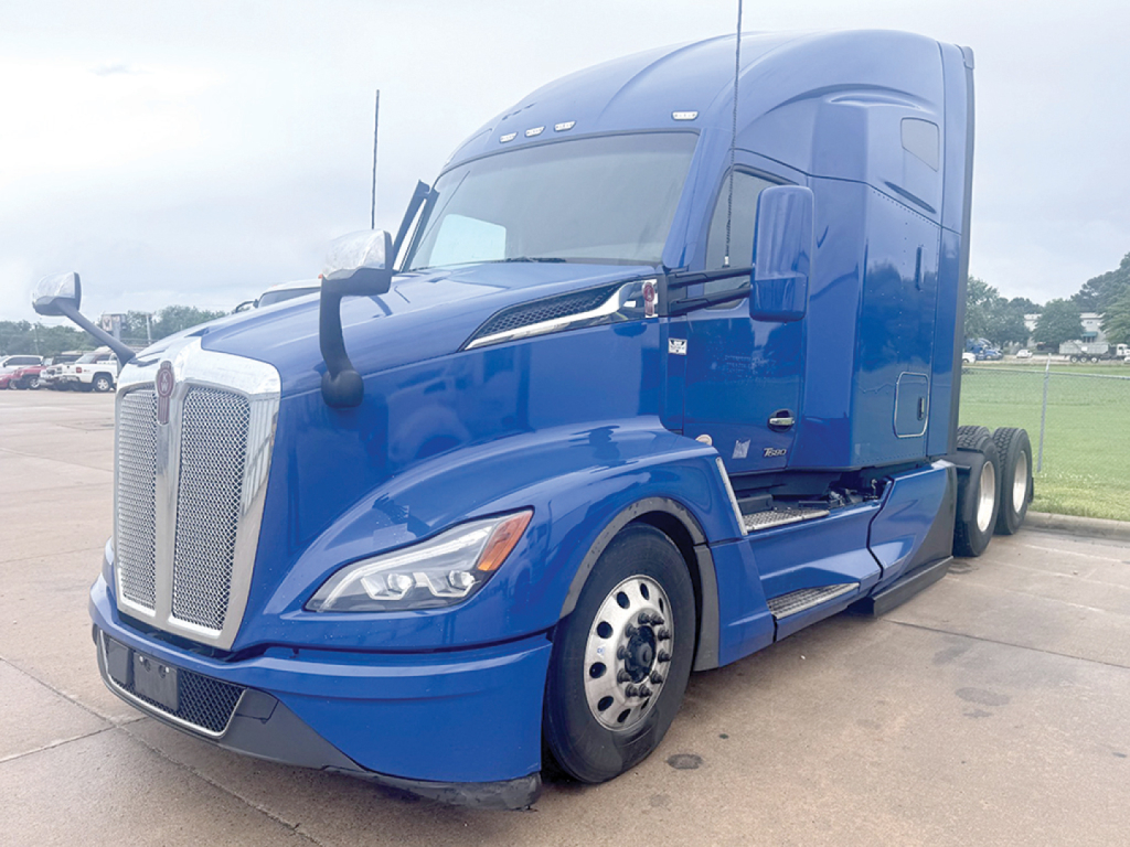 Kenworth T680 Next Gen truck in blue front-left view showing cab, grille, and wheel details.