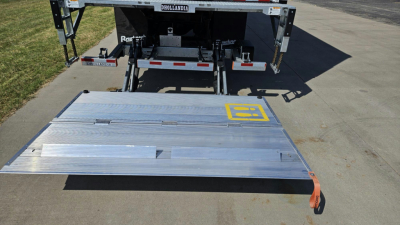 New 2025 Mack MD6 box truck rear deck with aluminum ramp and yellow EZ latch visible.