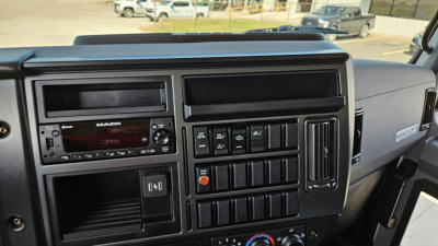 Dashboard of a 2025 Mack MD6 showing radio, climate controls, and switch panels in a box truck cab.