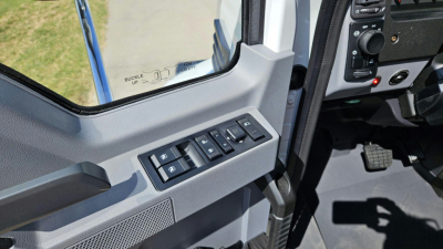 Vehicle cabin interior showing window controls on the driver's door and part of the dashboard in a Mack MD6 truck.