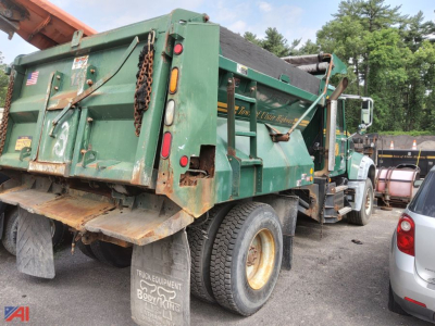 Green Mack Granite dump truck with plow attachment, side view showing rear dump bed and tires.