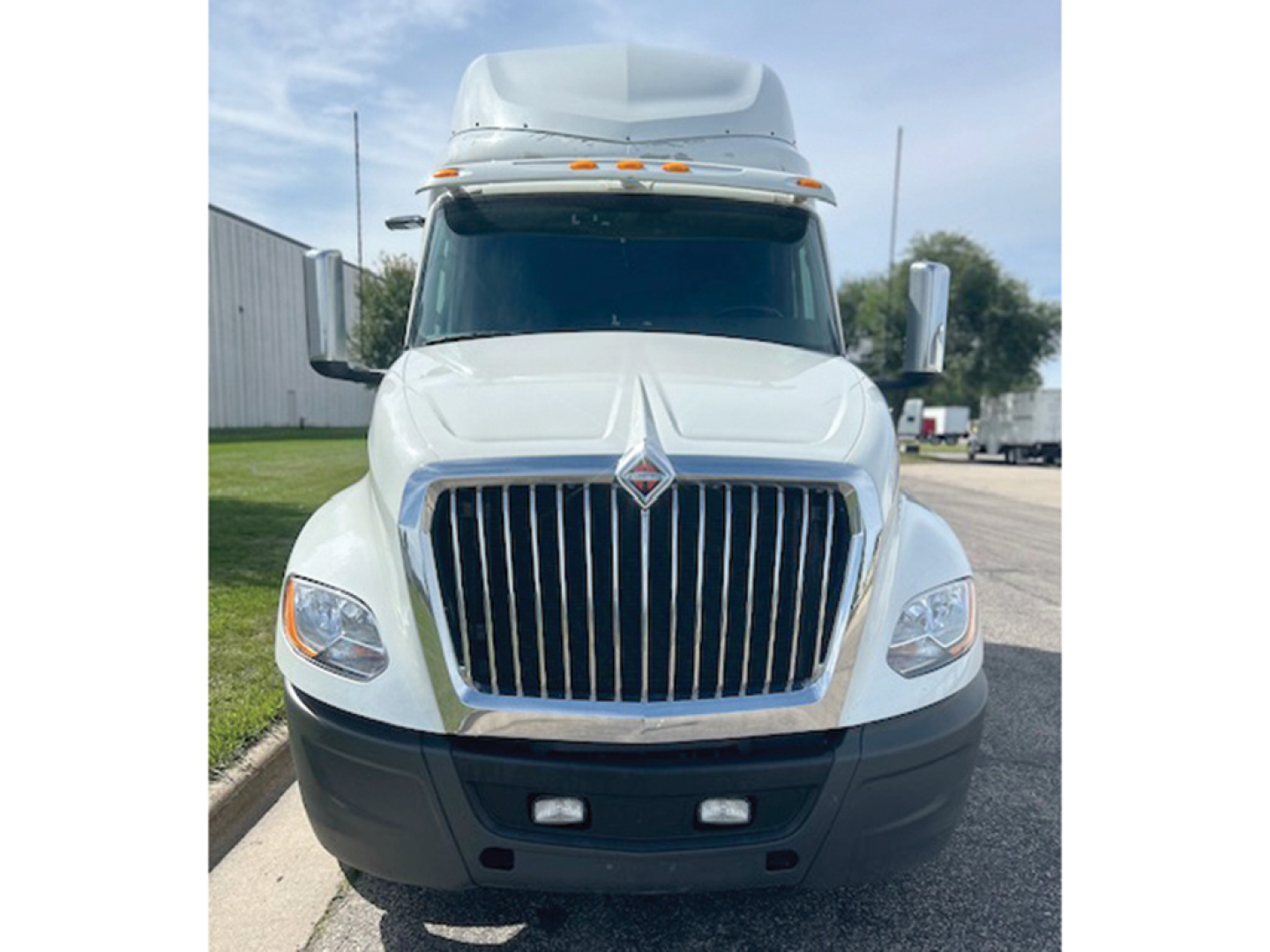 International LT625 truck front view showing chrome grille, large bumper, daytime running lights, and elevated cab with aerodynamic roof fairing.