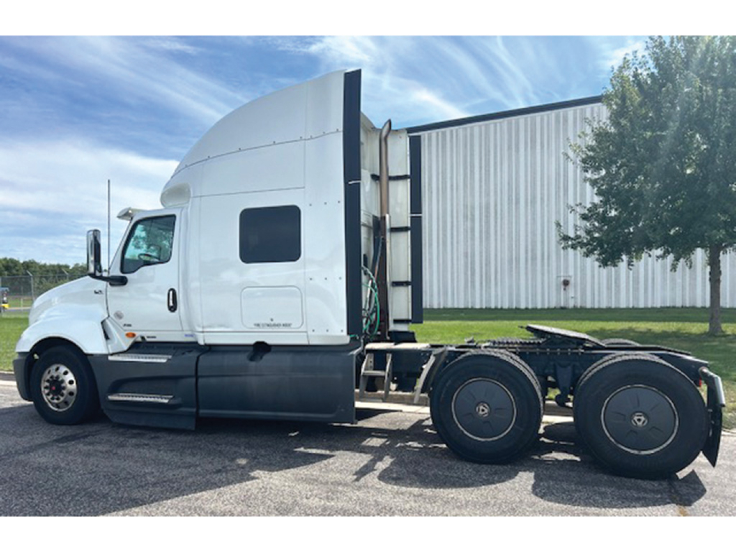 International LT625 truck cab and frame view with sleeper in white, side profile, showing rear wheels and trailer hitch area.