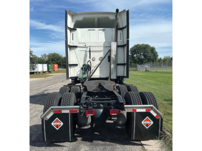 Truck rear view showing fifth wheel and dual sleeper tractor, chassis and rear tires, fuel/air lines, with reflective triangles.