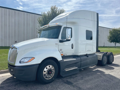 Truck image: 2021 International LT625 conventional sleeper tractor. Visible text: none clearly legible on side; VIN, stock number not on image; general truck features: white cab, black bumper, dual rear axles.
