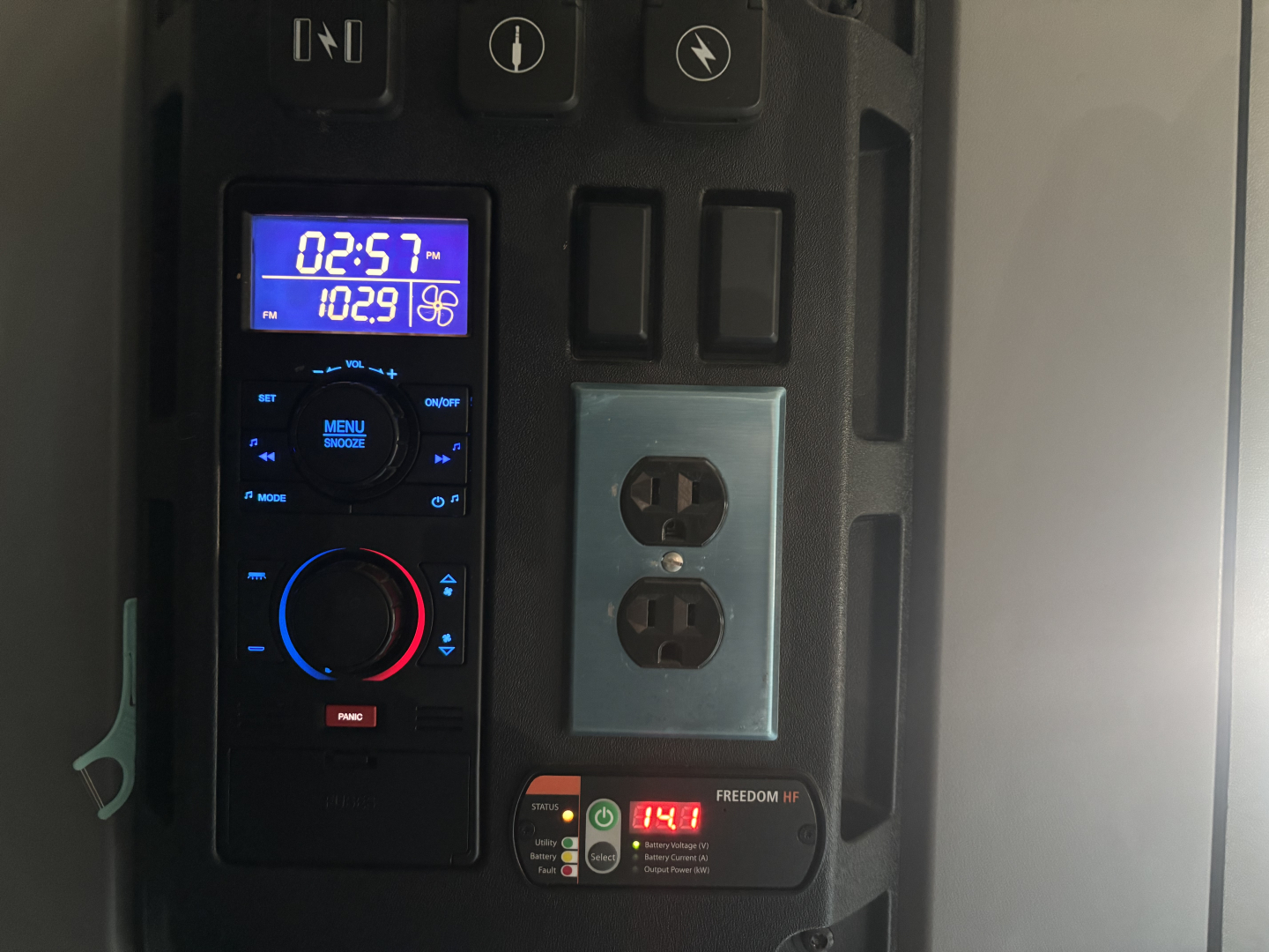 Dashboard and control panel of a Mack AN64T70 sleeper cab showing digital gauge and power outlets.