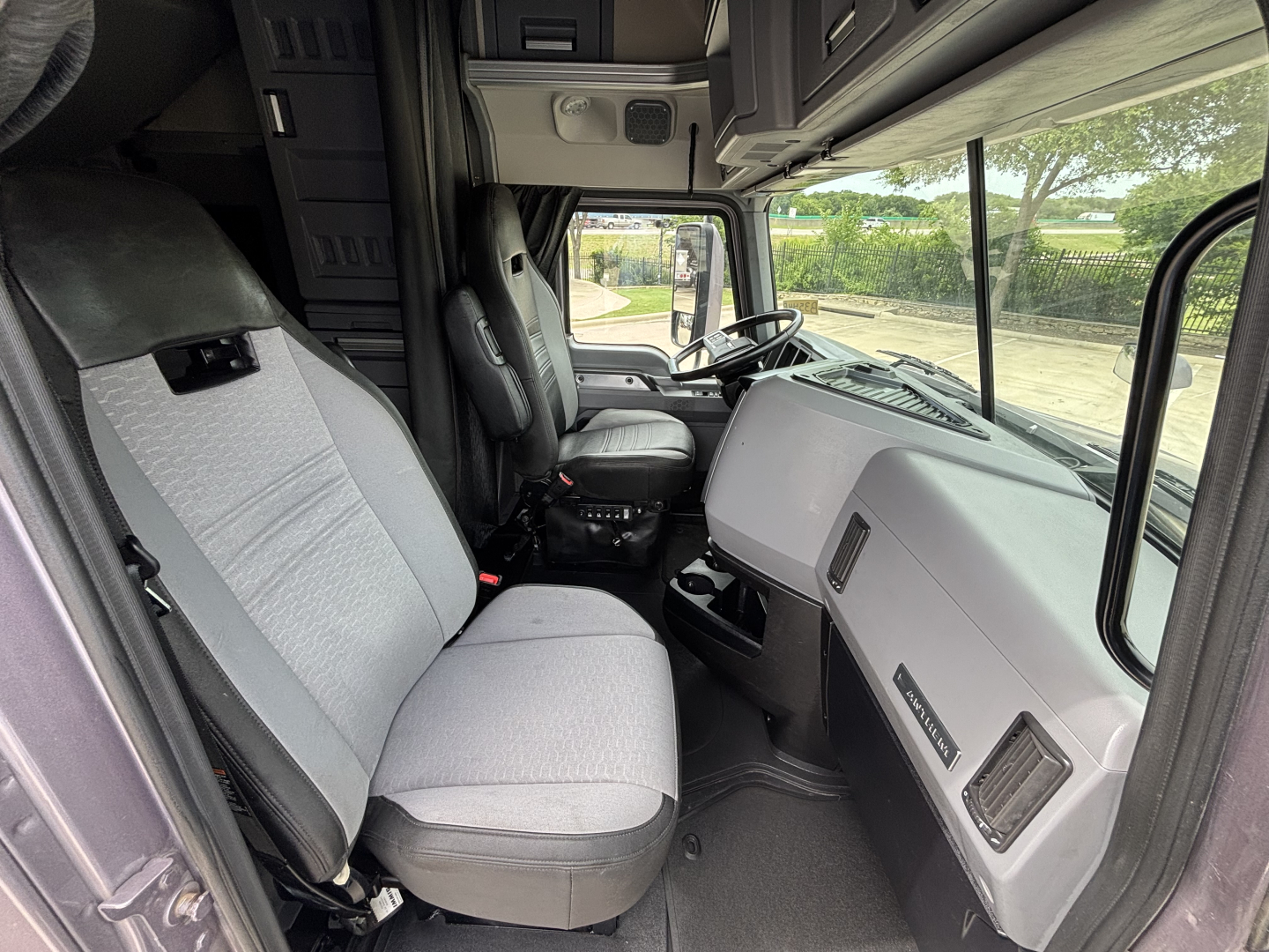 Interior of 2023 Mack AN64T70 sleeper cab showing steering wheel, dashboard, and front seats.