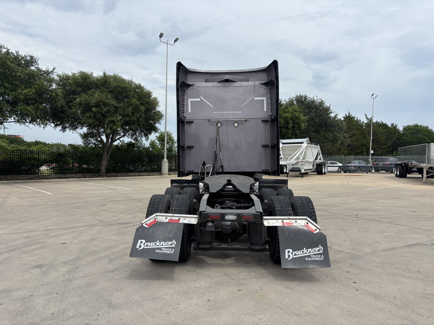 Rear view of a Mack AN64T70 truck chassis in a lot. Visible text on mud flaps reads 'Brackner's' and on the left mud flap 'HOLZWORTH' (partially). No other legible labels visible in the image.