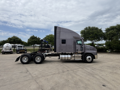 Truck tractor side profile with sleeper cab showing chrome fuel tanks and Mack styling, no visible model badge readable.
