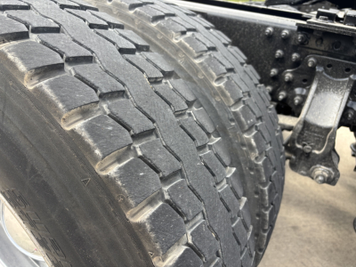Truck axle twin rear tires showing tread and suspension components.