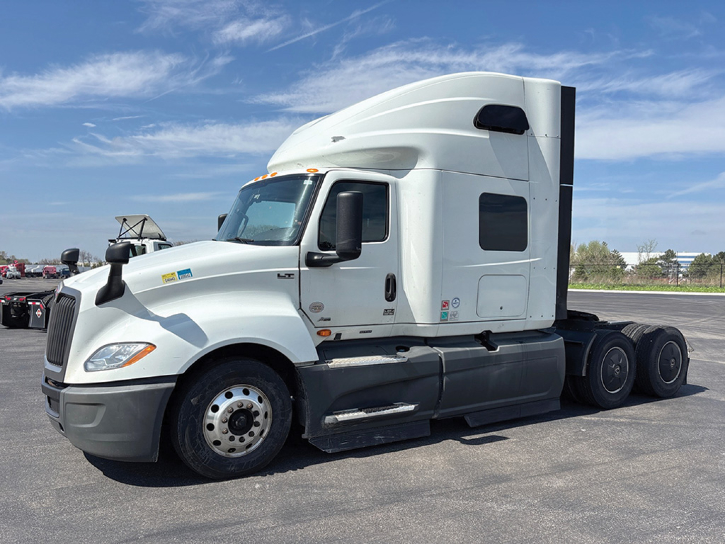 Truck tractor in sleeper configuration showing International LT625 with white cab and aerodynamic sleeper, side view, no visible damage.