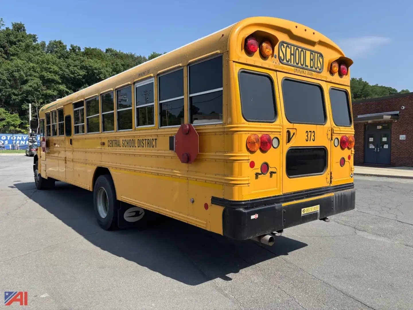 School bus rear view showing yellow body, 'SCHOOL BUS' sign, rear lights, and black bumper.