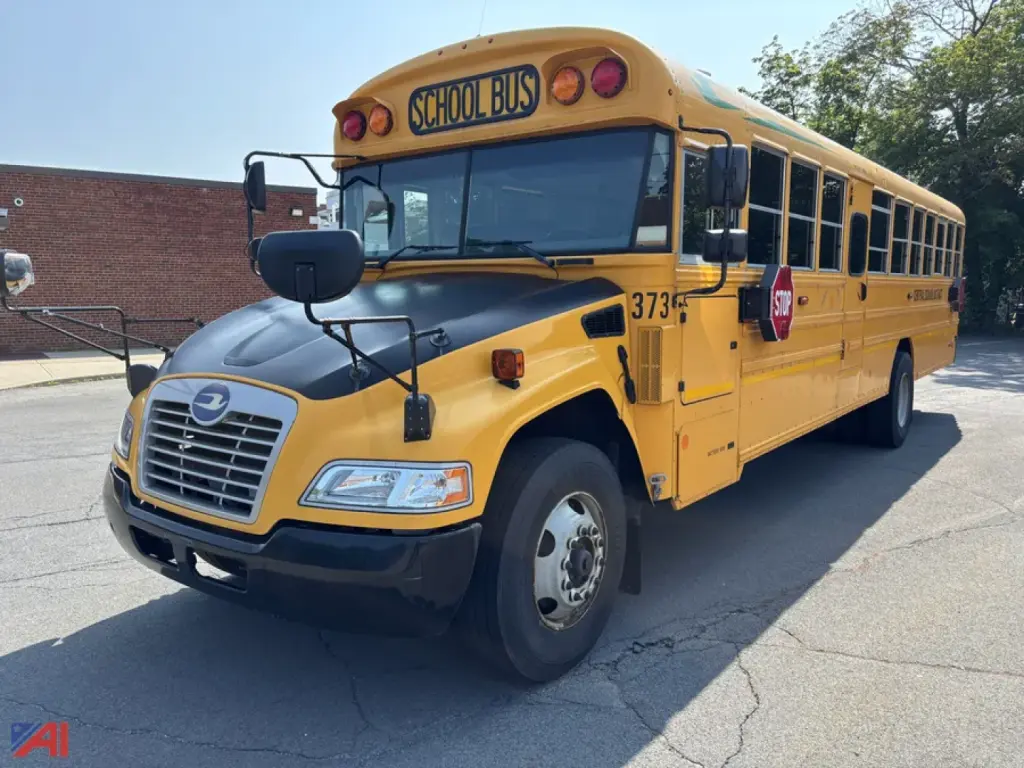 School bus in yellow color with front chrome grille, large windshield, stop sign extended, “SCHOOL BUS” sign on top, blue bird logo on hood, model number 3735 visible, daytime exterior shot.