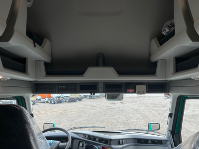 Truck cab interior/overhead area showing storage compartments and dash view through windshield.