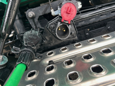 Volvo VNL64T860 engine bay view showing red locking cap and black electrical connector near polished aluminum valve cover