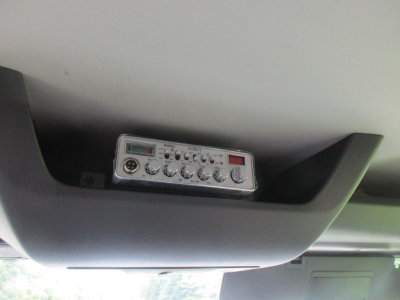 In-cab view showing a small control panel mounted overhead with multiple knobs and a digital display.