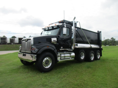 Western Star 49X dump truck in black with chrome accents, side view showing triple rear axles and dump bed. VIN tag not visible.