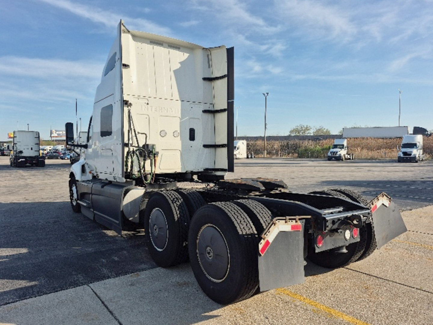 International LT625 truck tractor rear view showing sleeper cab and dual rear axles with fifth wheel and accessible cables.