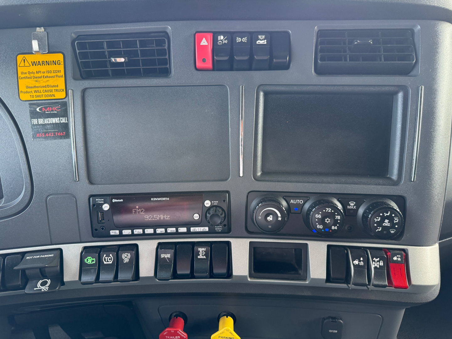 Kenworth T680 dash panel with control switches, air vents, and radio showing 9220? on display; various gauges and knobs visible in dash area.
